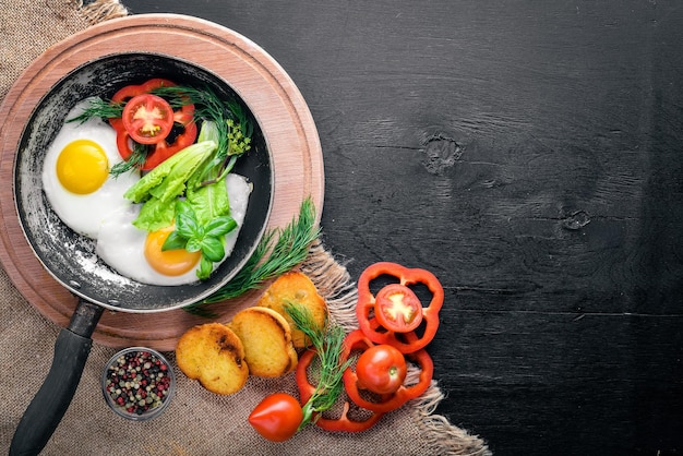 Œuf frit aux herbes pain grillé et légumes dans une poêle Vue de dessus Espace libre