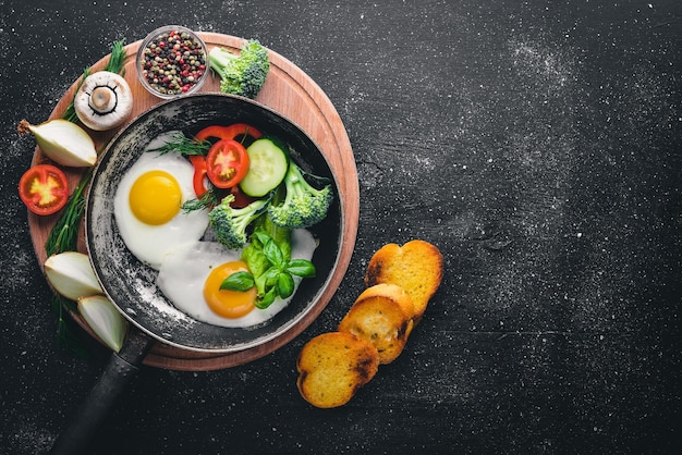 Œuf frit aux herbes pain grillé et légumes dans une poêle Vue de dessus Espace libre