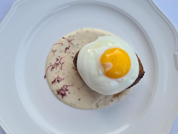 Œuf frit avec escalope et sauce dans une assiette sur la table