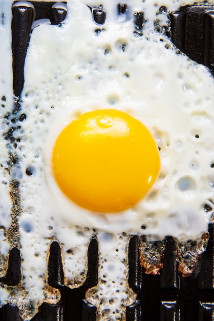 Œuf frit sur une poêle noire, grill