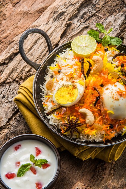 uf indien Biryani ou riz anda servi dans du kadhai ou du kadai avec trempette au yaourt, mise au point sélective