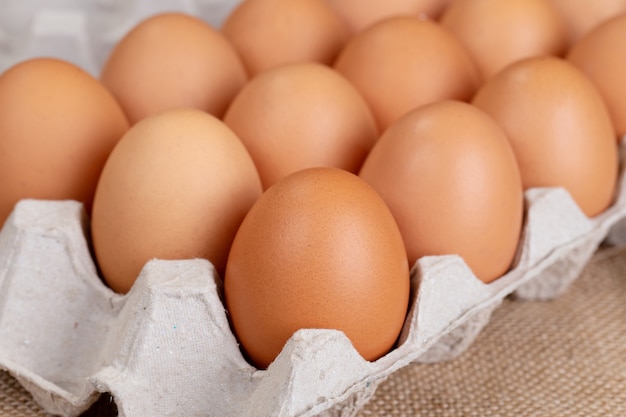 Œuf, œuf de poulet.Oeufs dans une boîte en carton sur un tissu.