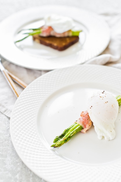 Œuf poché sur des asperges grillées au bacon.