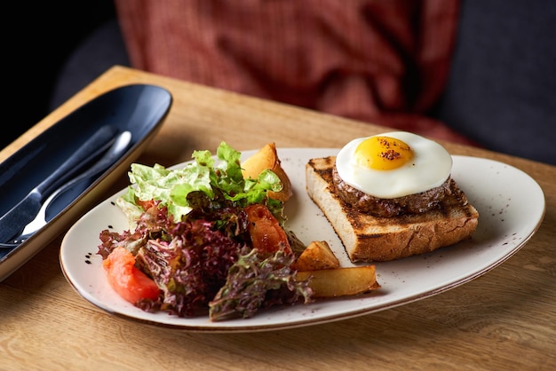 Œufs brouillés avec steak petit-déjeuner anglais classique avec des quartiers d'œufs et de pommes de terre