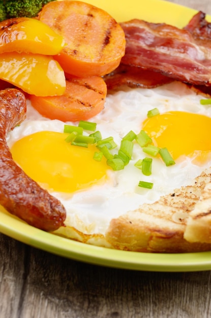 Œufs frits avec saucisses au bacon et légumes verts