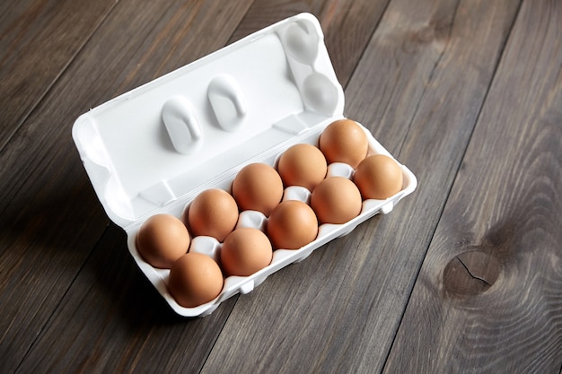 Œufs de poule dans le bac sur une table en bois marron