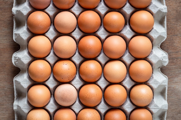 Œufs de poule fraîche œufs dans le bac à papier, carton d&#39;œufs sur fond en bois.