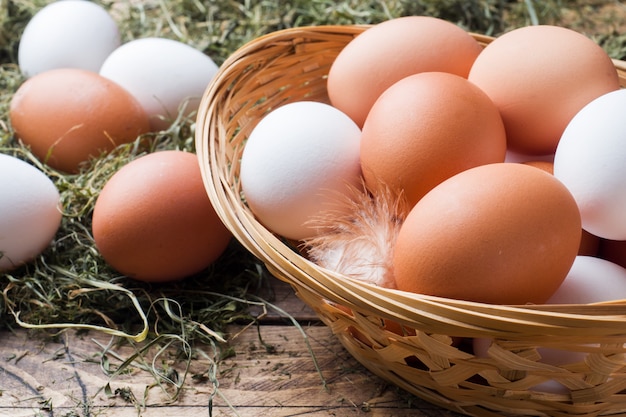 Œufs de poule frais dans un panier sur paille à la ferme