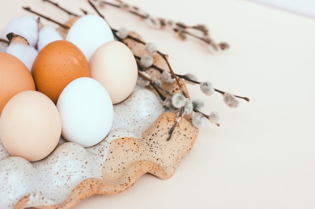 Œufs de poule de Pâques non peints dans un support d'oeufs en céramique.