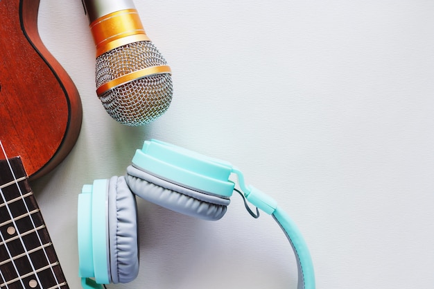 Photo ukulele avec casque vert et microphone sur fond blanc