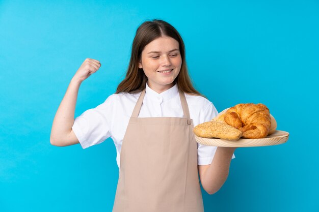 Uniforme de chef adolescent ukrainien. Boulanger tenant une table avec plusieurs pains célébrant une victoire