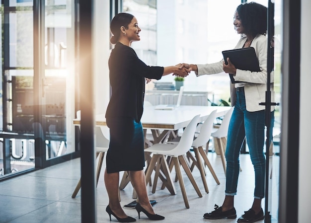 Photo unir leurs forces en un duo dynamique photo de deux femmes d'affaires se serrant la main dans un bureau