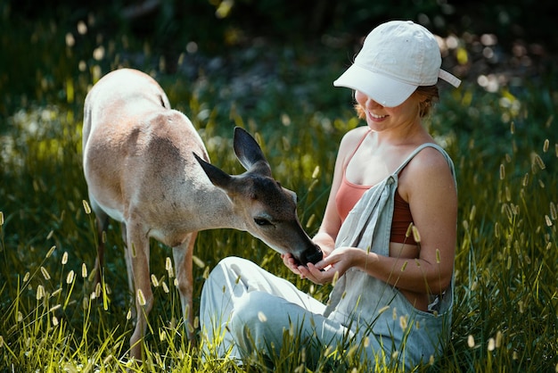 Unité avec la nature fille nourrir le cerf bambi concept d'animaux sauvages femme nourrir l'animal fauve au parc