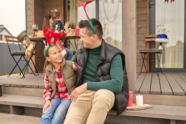 Unité. Papa assis avec sa fille sur les marches de la maison