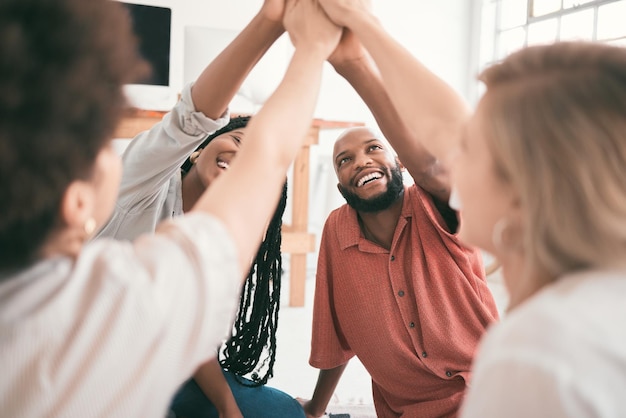 Unité de travail d'équipe et high five de jeunes étudiants s'amusant assis ensemble dans une pièce Divers amis montrant leur soutien tout en étant unis et en profitant de leur session d'étude ou de leur projet de groupe