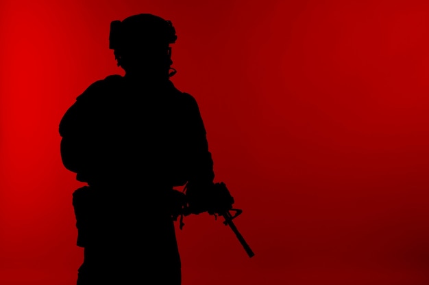 United States Marine Corps commande des opérations spéciales Marsoc raider avec arme. Silhouette de l'opérateur spécial Marine fond rouge