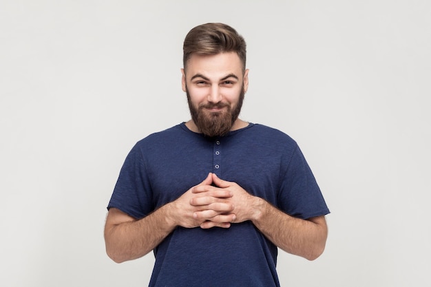 Unning businessman a croisé les mains et regardant sournoisement la caméra