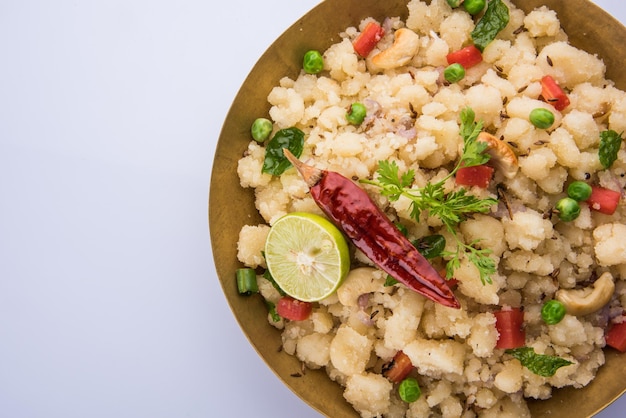 Upma ou Uppittu est un plat de petit-déjeuner populaire en Inde du Sud et au Maharashtra. La semoule ou le rava ou la farine de riz grossier sont les ingrédients principaux. Servi dans un bol sur fond coloré ou en bois