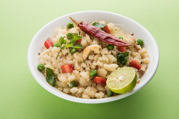 Upma ou Uppittu est un plat de petit-déjeuner populaire en Inde du Sud et au Maharashtra. La semoule ou le rava ou la farine de riz grossier sont les ingrédients principaux. Servi dans un bol sur fond coloré ou en bois