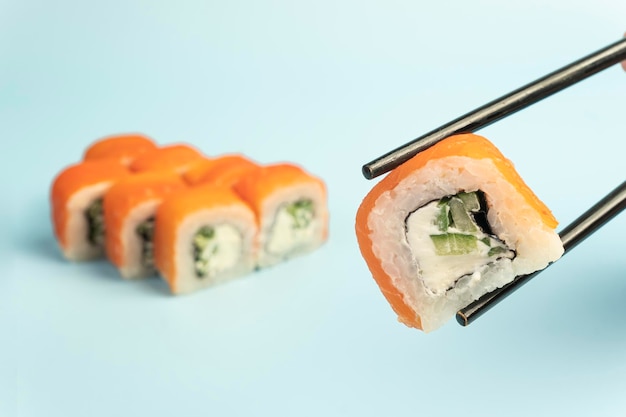 Uramaki Philadelphia classic sur fond bleu saumon fromage Philadelphia concombre avocat tobiko cuisine traditionnelle japonaise