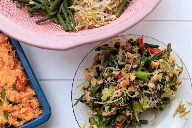 Urap Sayur, plat de salade traditionnel indonésien à base de divers légumes cuits à la vapeur mélangés avec de la noix de coco râpée assaisonnée et épicée pour la vinaigrette