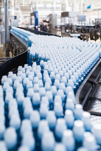 Photo usine d'embouteillage - ligne d'embouteillage d'eau pour le traitement et l'embouteillage d'eau de source pure dans des bouteilles bleues. mise au point sélective.