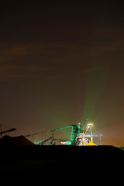 Usine de gravier illuminée la nuit