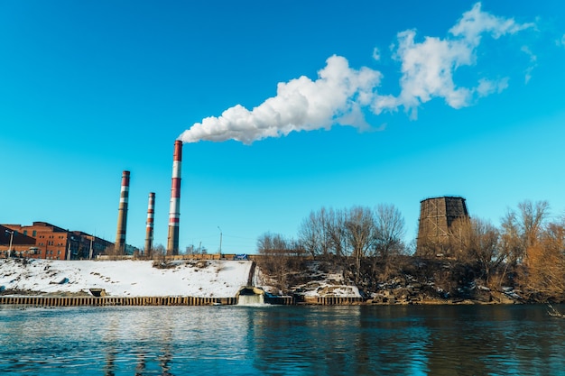 L'usine libère de la fumée blanche de pollution à travers le gros tuyau