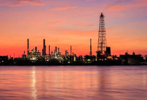 Photo usine de raffinerie de pétrole dans la silhouette et le lever du soleil