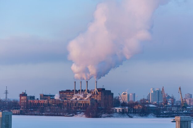 Usine de la ville.Photos de fabrication de travail avec les nuages de fumée à l'arrière-plan des bâtiments urbains en hiver.