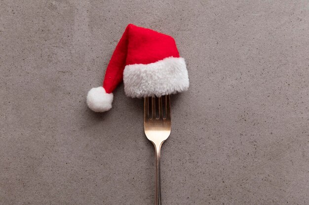 Ustensile de fourchette de fond de nourriture de Noël portant un chapeau de père Noël festif