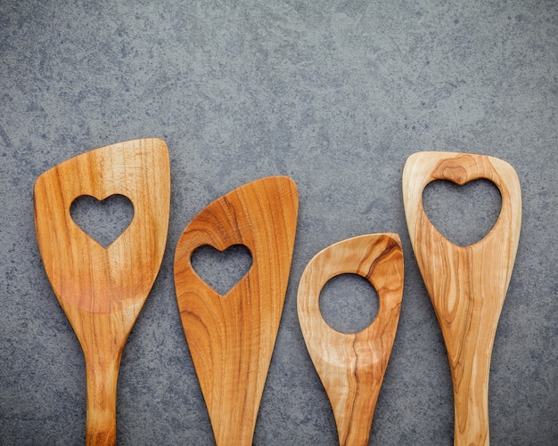 Les ustensiles de cuisine en bois bordent sur fond de pierre sombre.