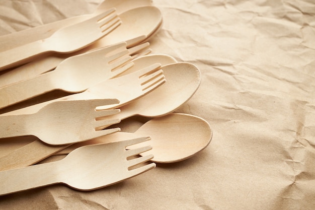 Photo ustensiles de cuisine jetables écologiques sur fond de papier. regardez d'en haut. fourchettes et cuillères en bois. concept écologique