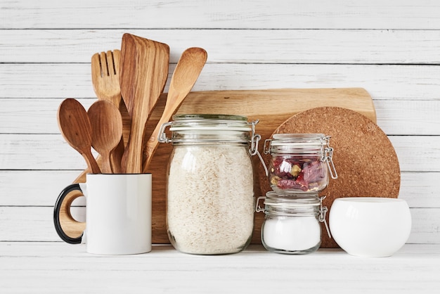 Ustensiles de cuisine et planche à découper sur une table blanche