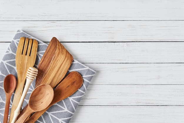 Ustensiles de cuisine, spatule et serviette sur un fond en bois blanc avec espace de copie