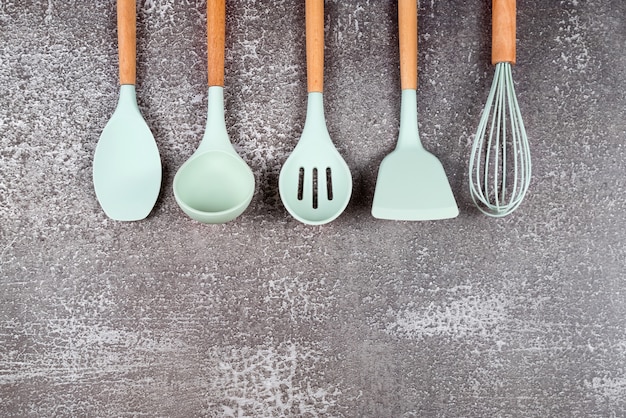 Ustensiles de cuisine, ustensiles de cuisine maison, accessoires en caoutchouc menthe sur fond sombre. Restaurant, cuisine, culinaire, thème de la cuisine. Spatules et pinceaux en silicone, espace libre pour le texte.