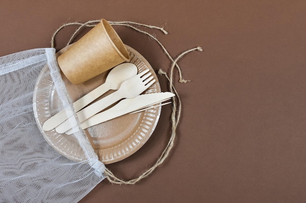 Ustensiles en papier carton jetables écologiques zéro déchet sur fond marron