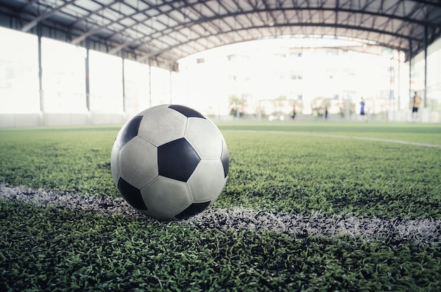 Usure usée du football noir et blanc classique sur le terrain d'entraînement