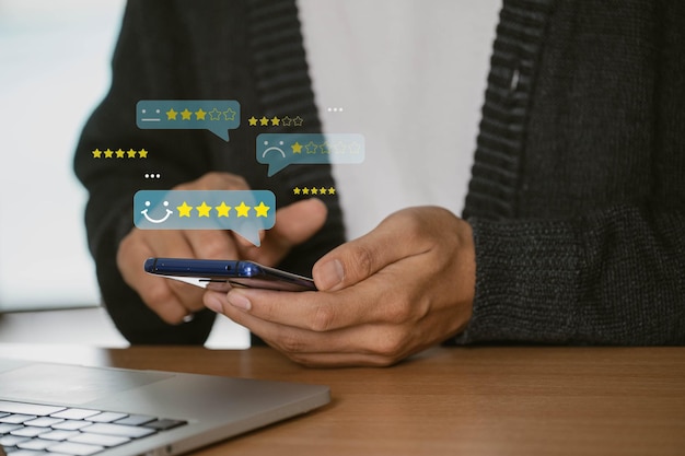 L'utilisateur donne une note de cinq étoiles en utilisant un smartphone sur l'application en ligne pour l'examen de la satisfaction du client idée d'enquête de rétroaction les utilisateurs évaluent leur expérience de service