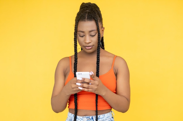Utilisateur de gadget Communication mobile Connexion 5G Femme du millénaire SMS message sur téléphone isolé sur fond orange