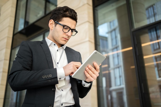 Utilise le téléphone dans ses mains pour communiquer avec le client Un homme d'affaires se rend au bureau