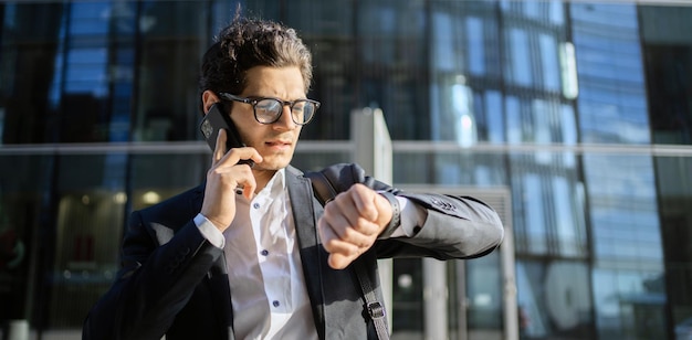 Utilise le téléphone lit le gestionnaire de messages un homme en costume d'affaires se rend au bureau