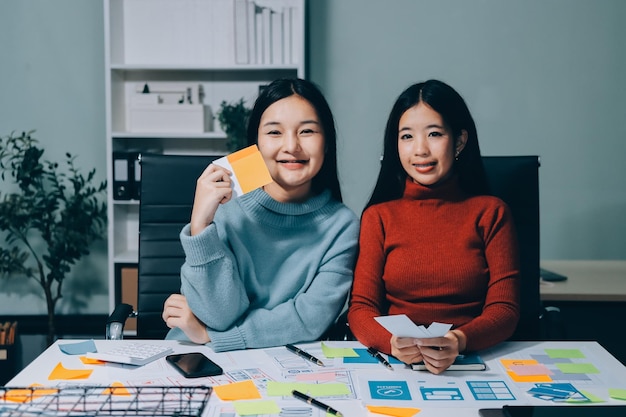 UX UI designer testing prototype on a phone discussing and brainstorming on wireframes for a website and mobile app prototype in the concept of website and mobile application design concept