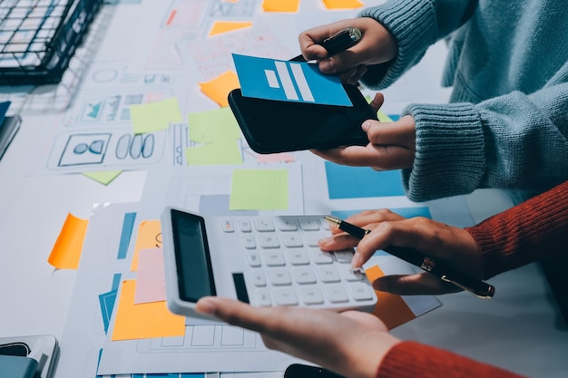 UX UI designer testing prototype on a phone discussing and brainstorming on wireframes for a website and mobile app prototype in the concept of website and mobile application design concept