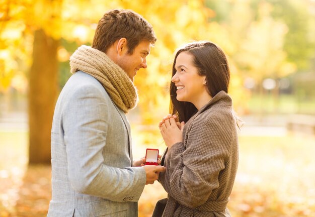 vacances, amour, couple, relation et concept de rencontres - homme romantique proposant à une femme dans le parc en automne