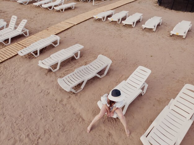 Vacances et aventure. Vue de dessus du drone à la plage, chaise de plage et fille de détente