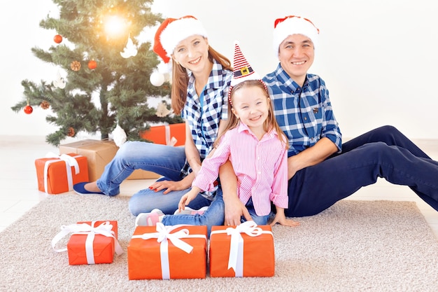 Vacances et concept festif - Portrait de famille heureux par arbre de Noël.