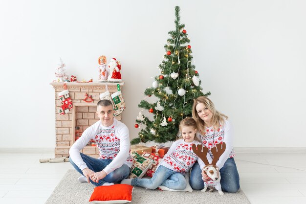 Vacances et concept festif - Portrait de famille heureux par arbre de Noël.