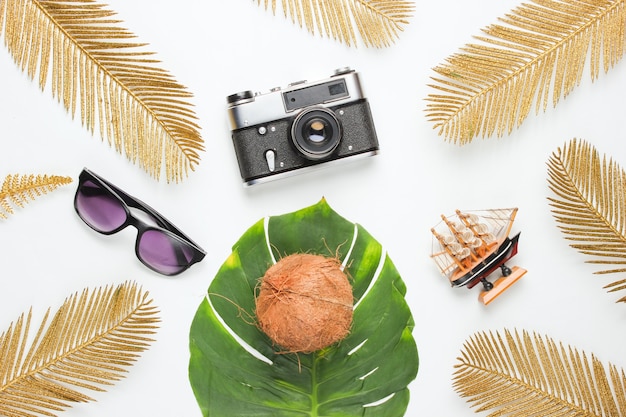 Vacances créatives sur fond de mer. Accessoires de plage de voyage sur fond avec monstera vert et feuilles de palmier tropical doré. Vue de dessus