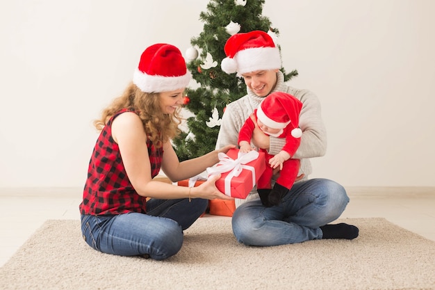 Vacances, Enfants Et Concept De Famille - Couple Heureux Avec Bébé Célébrant Noël Ensemble à La Maison.